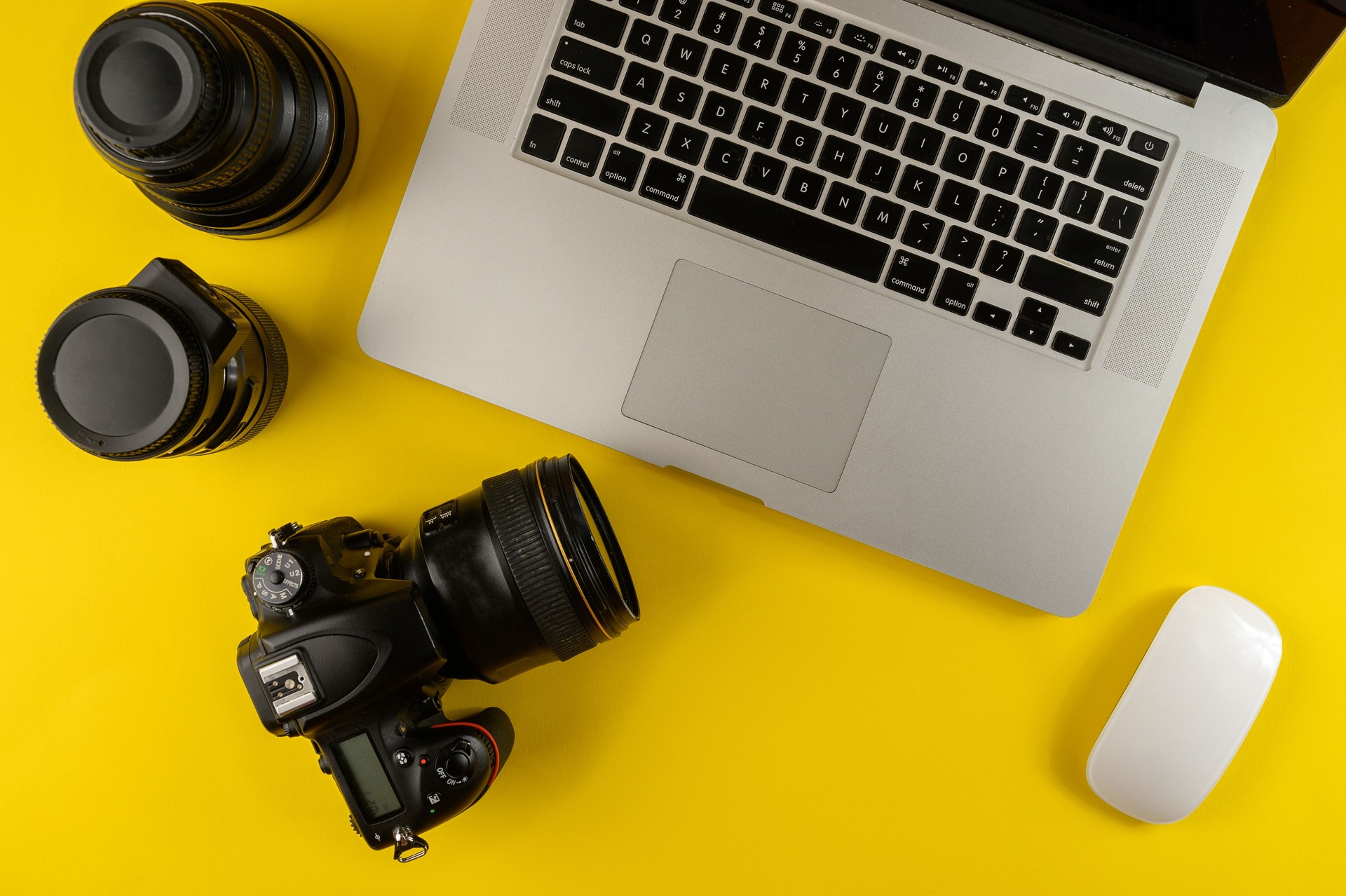 Photographer's equipment.Flat lay composition with photographer's equipment and laptop on yellow background