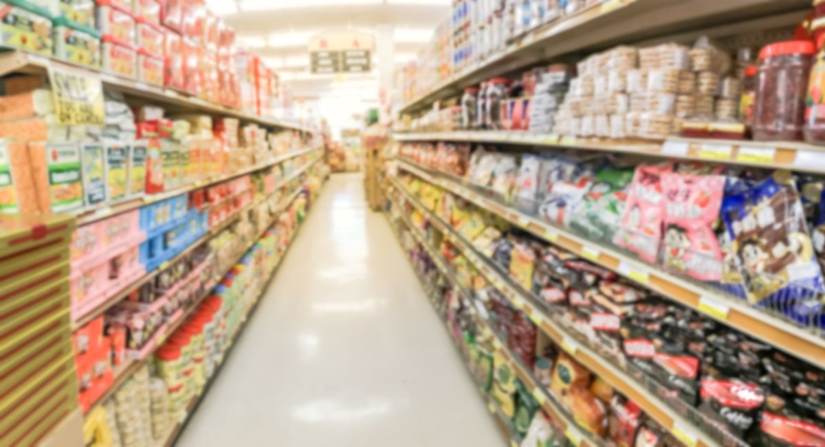 Panorama view blurred abstract candy, cookies, beef jerky, snack time at Asian grocery store in Garland, Texas, USA. Defocused sweet treats aisle on display with price tags at department supermarket